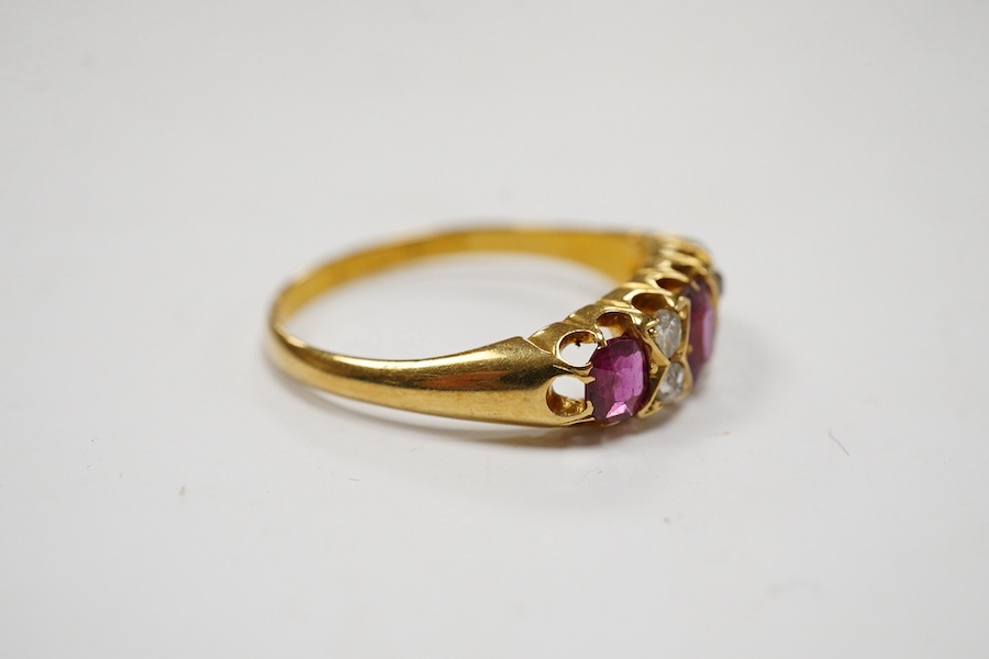 A late Victorian 18ct gold and three stone ruby set half hoop ring, with four stone diamond chip spacers, size P/Q, gross weight 3.2 grams. Condition - poor to fair